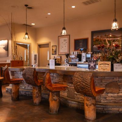 Bar area with wooden log stools, counter and hanging lignts.