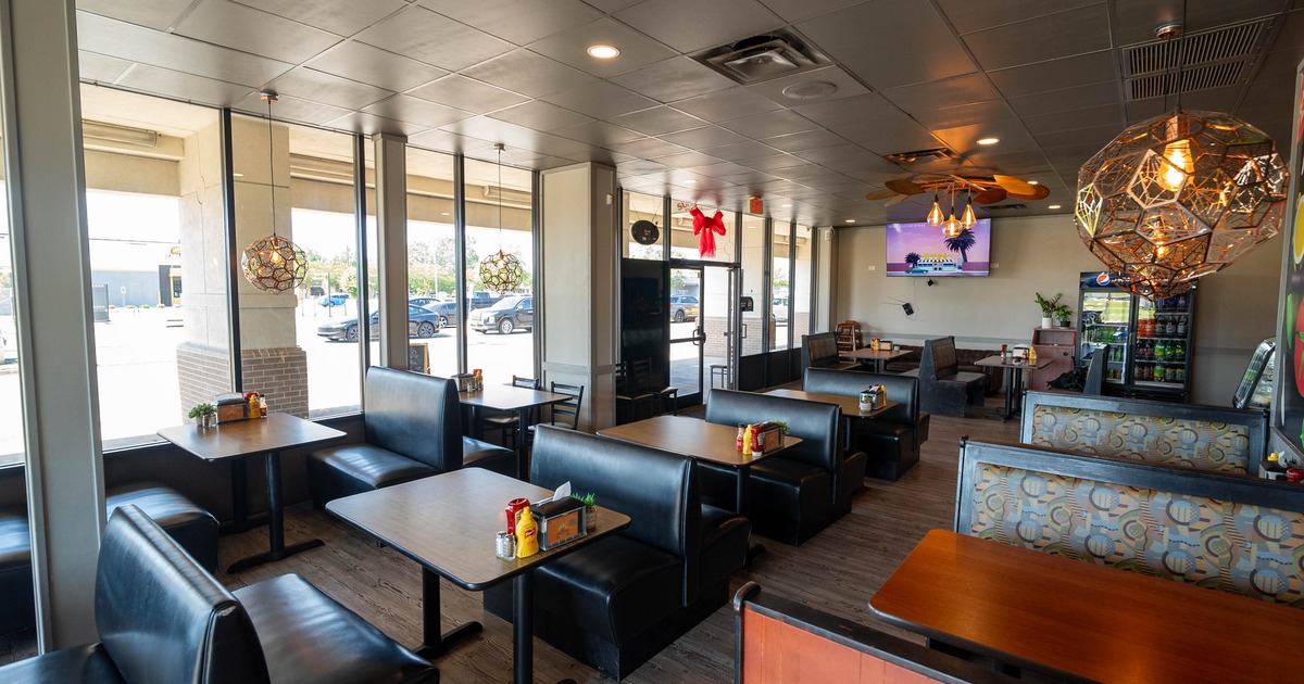 Interior, seating area featuring booths, a mural wall, and large windows