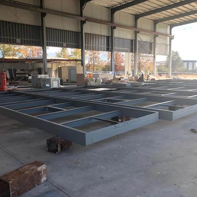 A steel frame is being built in a warehouse like space