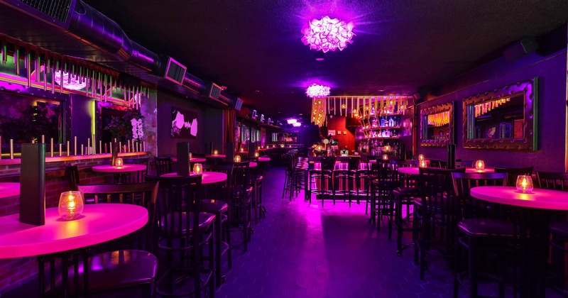 Interior, wide view to the restaurant, tables and chairs, bar behind