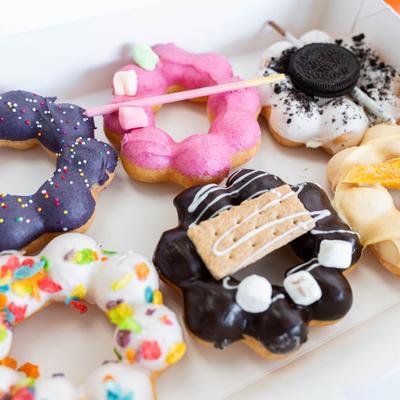 A box of colorful, chewy mochi donuts featuring various sweet, creative toppings.