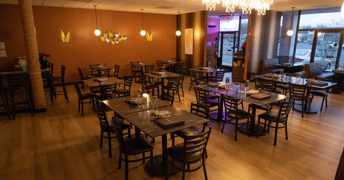 Interior, open space dining area, tables for six and four, restaurant entrance