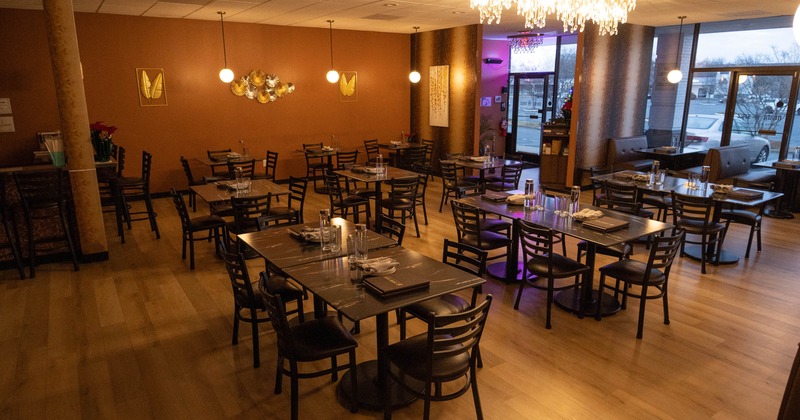 Interior, open space dining area, tables for six and four, restaurant entrance