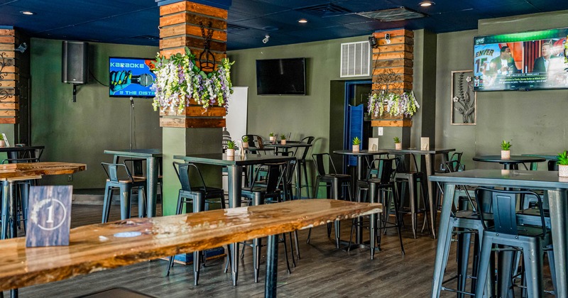 Interior are, tall tables, bar stools and TVs on the walls