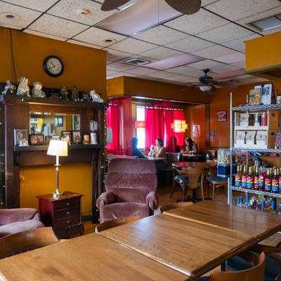 Cozy cafe interior with wooden tables and red curtains.