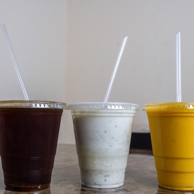 Three different beverages in disposable plastic cups.