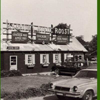 Old picture of a building with signs advertising Harrow's Rustic Roost restaurant.