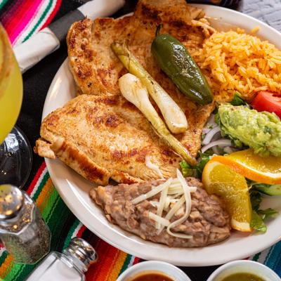 Grilled chicken with rice, refried beans, guacamole, jalapeno, and grilled spring onion.