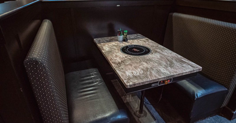 Cozy restaurant booth with dark leather seats and a wood-textured table