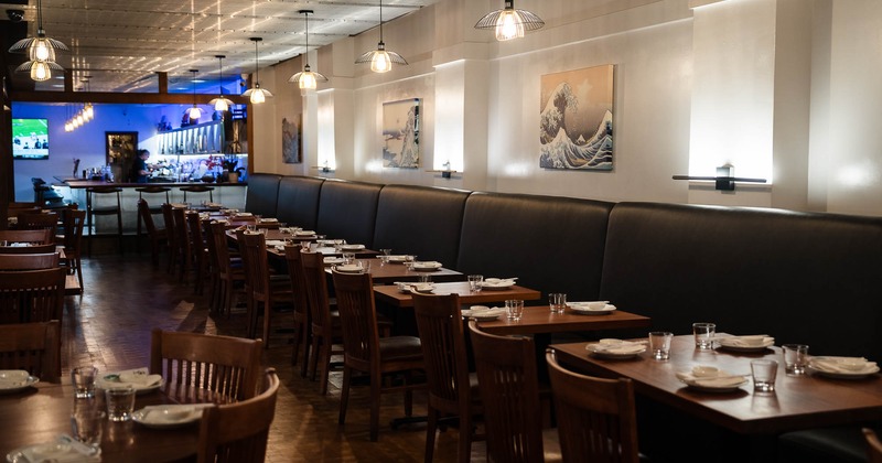 Interior, dining tables , chairs and banquette seating with pictures on the walls