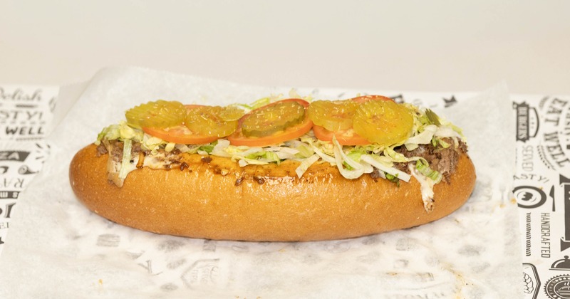 A classic meat and cheese hoagie topped with pickles, lettuce, and tomatoes