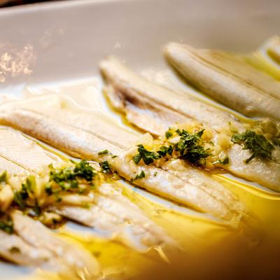 White anchovies marinated with olive oil, garlic, and parsley.