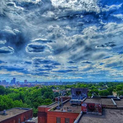Downtown skyline featuring a dramatic cloudy sky above rooftops.