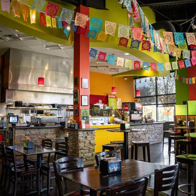 Interior, dining area, colorful decor with papel picado banners, stone counter.