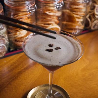 Espresso Martini being garnished with coffee beans.