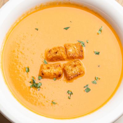 Butternut Squash Soup with croutons in a white bowl.