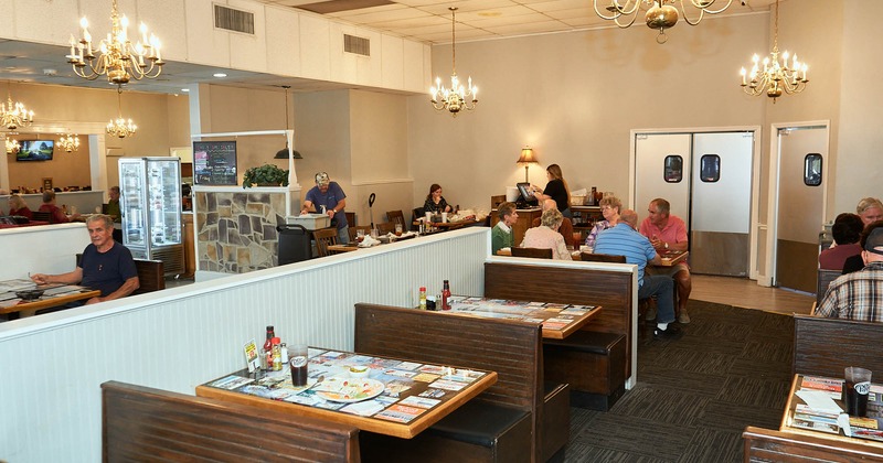 Interior, booths, benches, tables, customers, chandeliers, windows