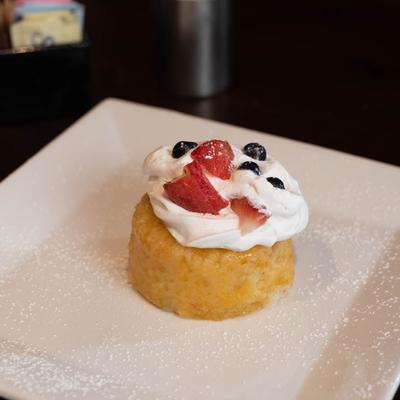 Shortcake topped with whipped cream and strawberry and bluberries.