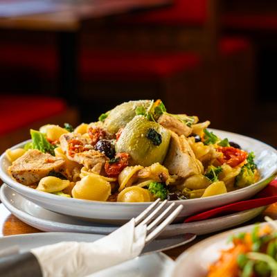 Orecchiette pasta with chicken, broccoli, tomato, artichoke, olives, and white wine sauce.