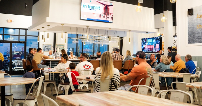 Interior space, bar and seating area with guests chatting and enjoying their drinks