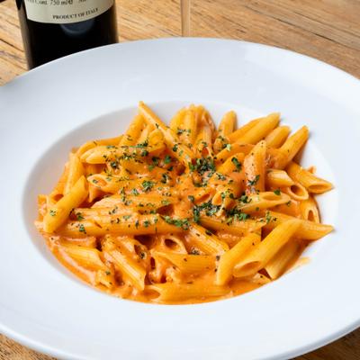 Penne alla vodka garnished with fresh herbs.