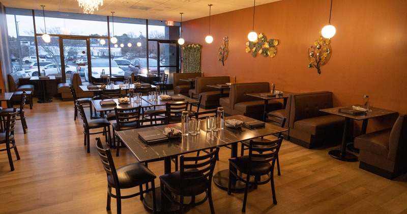 Interior, dining area, tables with chairs, seating booths with tables, large shop window,