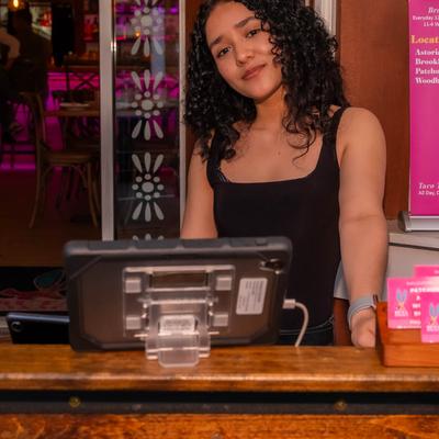 An employee standing behind checkout counter.