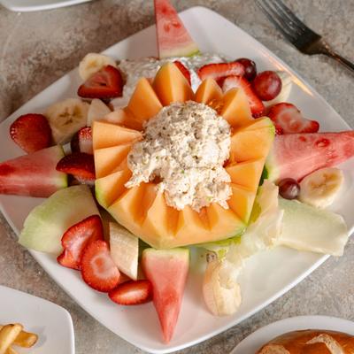 Chicken salad stuffed cantaloupe served with mixed fruit.