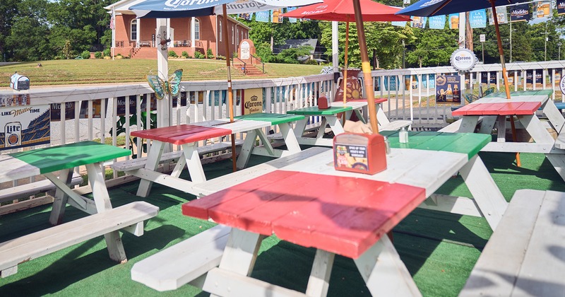 Outdoor seating area, a conjoined tables and benches, and parasols