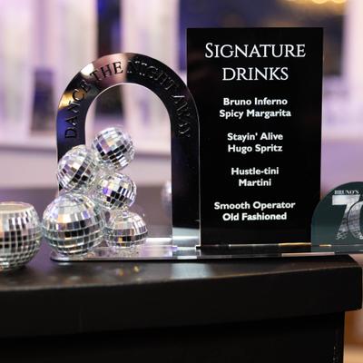 Signature drinks display sign with tiny disco ball decorations.