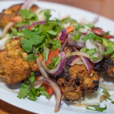 Grilled chicken topped with cilantro, red onions, and red peppers.