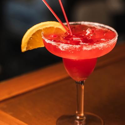 Red Margarita cocktail with salted rim and orange slice garnish.