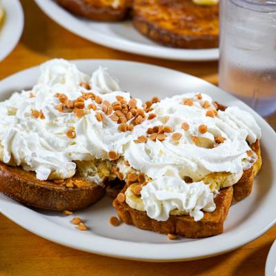 Funky monkey french toast topped with banana, whipped cream and toffee bits.