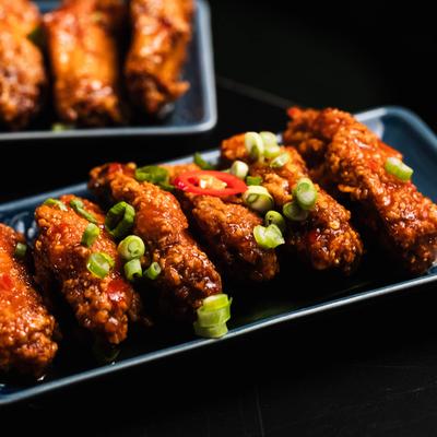 Fried chicken wings tossed in sriracha and sweet chili sauce, topped with scallions.
