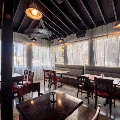 Indoor seating area with tables, chairs, and banquette