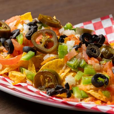 Nachos with black olives, peppers, and pickled jalapenos.