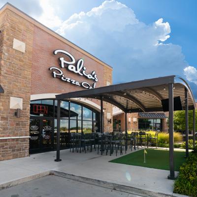 Exterior featuring a brick facade building with signage and a covered patio area.