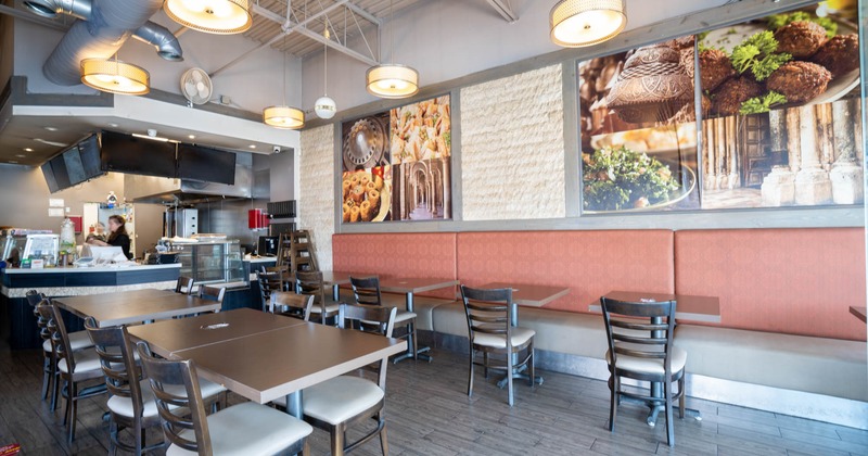 Interior of a casual dining restaurant with wood tables, bench seating, photographs on the wall