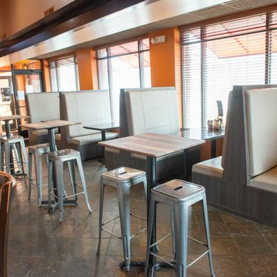 Dining area featuring a combination of high-top bar tables and booth seating.