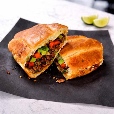 Torta sandwich with ground meat combined with tomatoes, onions and avocado.