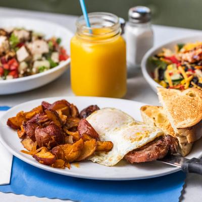 Breakfast Sampler, salads, and orange juice served in a mason jar.