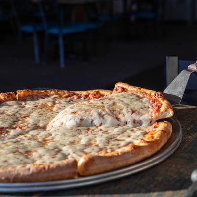A slice of cheese pizza being lifted from the pie.
