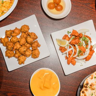 Multiple food plates on a wooden table.