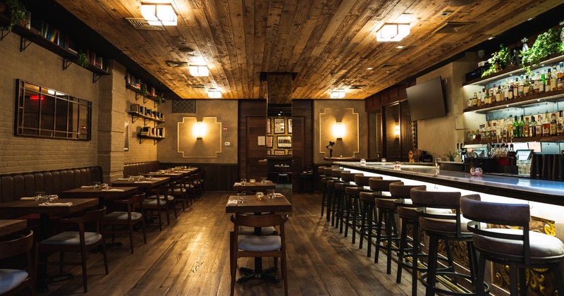 Interior, counter, tables, chairs, stacked bottles, lighting, book shelves