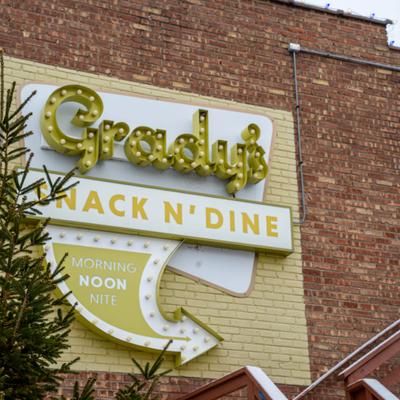 Restaurant exterior sign mounted on a brick wall.