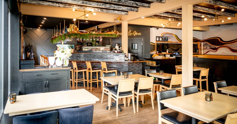 Interior, dining area, exposed wooden beams, tables with chairs, waiter serving station