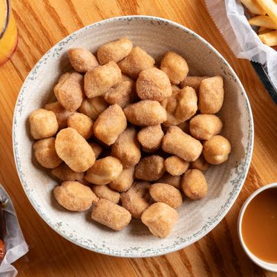 Bowl of Cinnamon Puffs served with a side of caramel sauce.