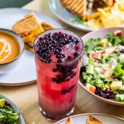 Blueberry Lavendar Lemonade served on the table alongside food.