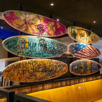 Colorful surfboards hanging above seating area.