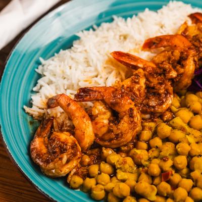 Rice bowl with grilled shrimp and chickpeas, close-up.